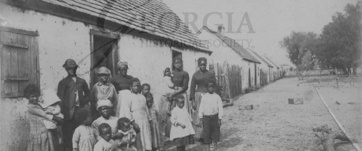 Former slaves in front of former slave cabins on St. Catherines Island, Georgia. Photograph taken between 1883 and 1892 by William E. Wilson