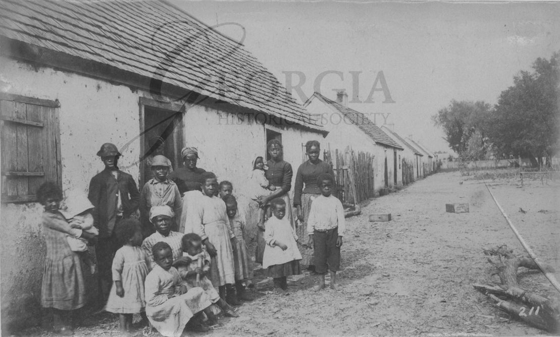 Former slaves in front of former slave cabins on St. Catherines Island, Georgia. Photograph taken between 1883 and 1892 by William E. Wilson
